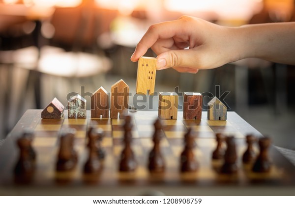 Building and house models in chess game,\
Business financial district and commercial , success and leadership\
business concept.