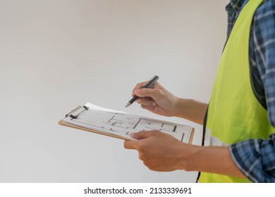 Building inspection, contractor asian young man, male inspecting home, reconstructed construction, renovation or check defect, before finish handing it over to client. Engineering worker, copy space. - Shutterstock ID 2133339691