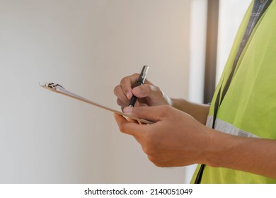 Building inspection, contractor asian young man, male inspecting home, reconstructed construction, renovation or check defect, before finish handing it over to client. Engineering worker, copy space. - Shutterstock ID 2140051049