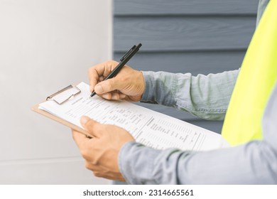 Building inspection, contractor asian young man, male inspecting home, reconstructed construction, renovation or check defect, before finish handing it over to client. Engineering worker, copy space. - Shutterstock ID 2314665561