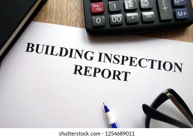 Building Inspection Report, Pen, Glasses And Calculator On Desk