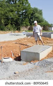Building inspector checking new electrical & plumbing pipes coming into new residential community