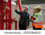 Building inspector man checking fire hose cabinet. engineer and worker in green vest, ear muffs and safety helmet working for building maintenance inspection.	
