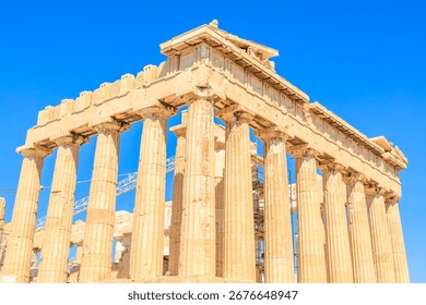The building is a large, ancient structure with many columns. The columns are made of stone and are arranged in a row. The building is located in a city and is surrounded by other buildings