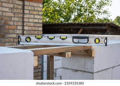 Building level. Measurement of the horizontal level of a wall. Building walls by level. Building level on the surface of the wall - Shutterstock ID 2359335385