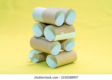 A Building Made Of Empty Toilet Paper Rolls On A Yellow Background. Background On The Theme Of Ecology And Recycling Of Materials.