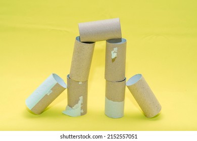 A Building Made Of Empty Toilet Paper Rolls On A Yello Background. Background On The Theme Of Ecology And Recycling Of Materials.