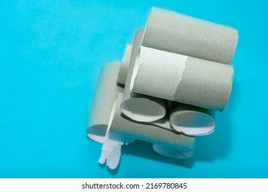 A Building Made Of Empty Toilet Paper Rolls On A Blue Background. Background On The Theme Of The Economic Crisis And The Lack Of Items For Basic Needs.