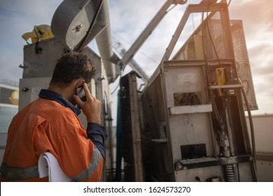 Building Maintenance Inspector Is Using Cellphone Calling Site Emergency Services When Building Maintenance Unit Is Broken Down Holding Rescue Plan On His Arm High Rise Building Sydney CBD Australia 