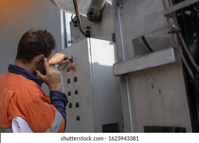 Building Maintenance Worker Holding Paperwork Is Using Cellphone Calling Site Emergency Services When Building Maintenance Unit Is Broken Down High Rise Building Sydney CBD Australia 