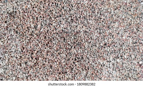 Building material from small multi-colored grains for wall cladding of buildings and houses