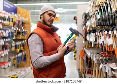 building materials stores a man chooses a new hammer - Shutterstock ID 2187138749