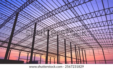 Building Metal Framework Design Background, Silhouette Industrial Factory Warehouse Structure in Construction Site against Colorful Blue Orange Sunset Sky 