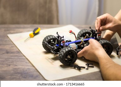 Building Model Cars. Radio Control Car Assembly Scene, RC Car Assembly On Wooden Work Desk And Tools. Building Model Cars. Radio Control Car Assembly Scene, RC Car Assembly On Work Desk And Tools.