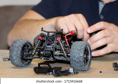 Building Model Cars. Radio Control Car Assembly Scene, RC Car Assembly On Wooden Work Desk And Tools. Building Model Cars. Radio Control Car Assembly Scene, RC Car Assembly On Work Desk And Tools.