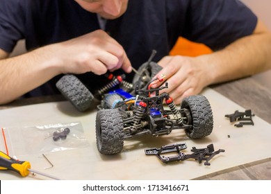 Building Model Cars. Radio Control Car Assembly Scene, RC Car Assembly On Wooden Work Desk And Tools. Building Model Cars. Radio Control Car Assembly Scene, RC Car Assembly On Work Desk And Tools.