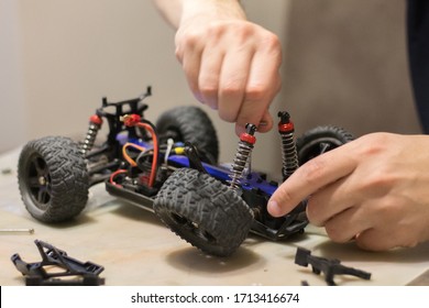 Building Model Cars. Radio Control Car Assembly Scene, RC Car Assembly On Wooden Work Desk And Tools. Building Model Cars. Radio Control Car Assembly Scene, RC Car Assembly On Work Desk And Tools.