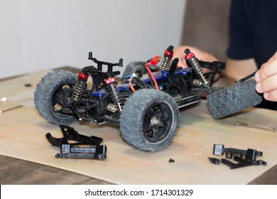 Building Model Cars. Radio Control Car Assembly Scene, RC Car Assembly On Wooden Work Desk And Tools. Building Model Cars. Radio Control Car Assembly Scene, RC Car Assembly On Work Desk And Tools.