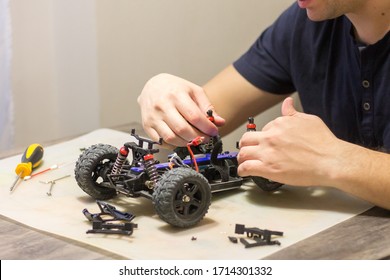 Building Model Cars. Radio Control Car Assembly Scene, RC Car Assembly On Wooden Work Desk And Tools. Building Model Cars. Radio Control Car Assembly Scene, RC Car Assembly On Work Desk And Tools.