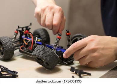 Building Model Cars. Radio Control Car Assembly Scene, RC Car Assembly On Wooden Work Desk And Tools. Building Model Cars. Radio Control Car Assembly Scene, RC Car Assembly On Work Desk And Tools.