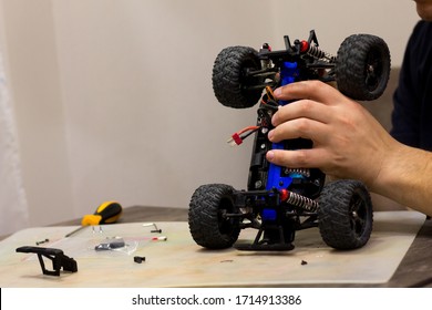 Building Model Cars. Radio Control Car Assembly Scene, RC Car Assembly On Wooden Work Desk And Tools. Building Model Cars. Radio Control Car Assembly Scene, RC Car Assembly On Work Desk And Tools.