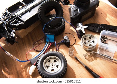 Building Model Cars. Radio Control Car Assembly Scene, RC Car Assembly On Wooden Work Desk And Tools. Natural Lighting.