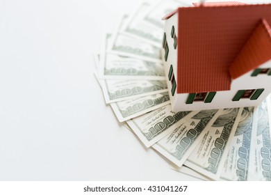 building, mortgage, investment, real estate and property concept - close up of home or house model and money