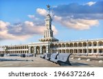The building of the new River Station with a star on the spire and benches in Moscow on a spring sunny morning. Inscription: Moscow - Volga 
