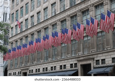 building in New York lined with American flags - Shutterstock ID 2366488033