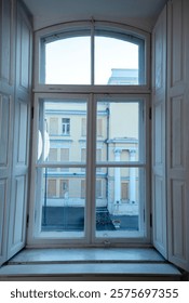A building next to a window. High quality photo, large window close-up. antique window with open shutters. window with wooden frame