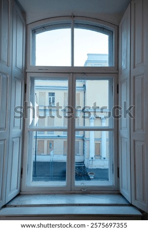 A building next to a window. High quality photo, large window close-up. antique window with open shutters. window with wooden frame