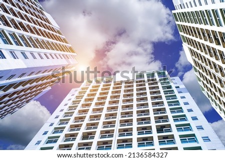 Building at noon in the city. Office and residential skyscrapers on the bright sun and clear blue sunset sky background.                              