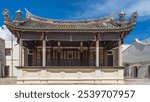 The building of the old historical Chinese theater of the Khoo Kongsi Temple house. The stage with columns is decorated with ornaments. A roof with curved edges and figures of mythical creatures.