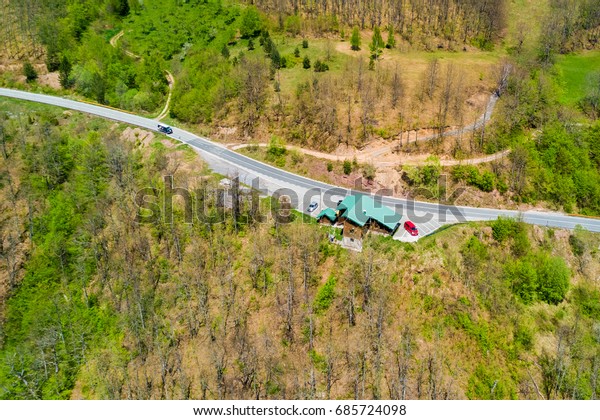 Building\
on the edge of the road in the forest, top\
view