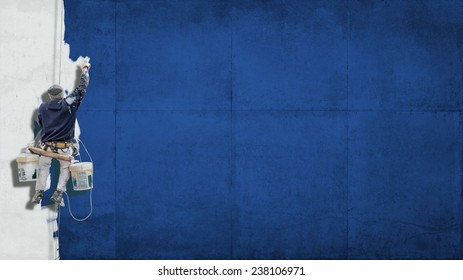 Building Painter Hanging From Harness Painting A Wall In Blue With Lots Of Copy Space For Your Own, Message