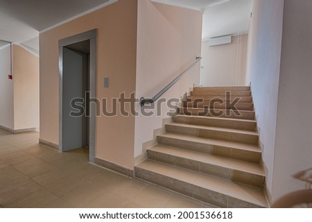 Building panel house interior with elevator and flight stairs. Precast concrete staircase. Flight of stairs. Flight of stairs are decorated building. Beautiful long staircase. Tile on floor.