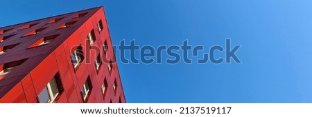 Building with red facade against blue sky background