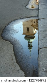 Building reflected in puddle
