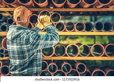 Building Residential Septic System Using Plastic Pipes. Caucasian Construction Worker Looking For Correct Pipe Diameter. Construction Supplies Store.