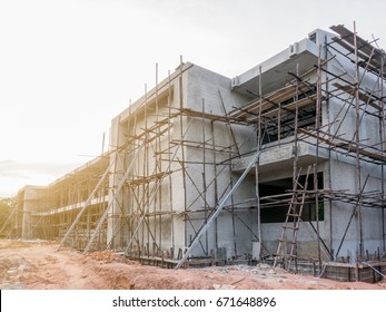 Building School Under Construction. The Building Construction  Has Wooden Structure For Plastering And Paint. Structure Is Color Of Concrete Mortar And Background Is Sky And Cloud Sunshine.