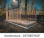 Building a shed outbuilding base and frame out of wood in backyard on gravel surface pad. Using various lumber and tools for this outdoor barn construction project.