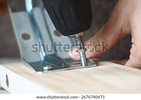 Building a shelf using a power drill for assembly