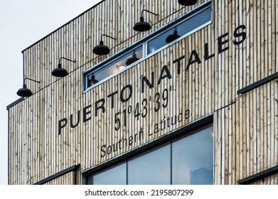 Building with a sign saying Puerto Natales 51degrees 43 minutes 39 seconds Southern Latitude. Puerto Natales, Chile - Shutterstock ID 2195807299