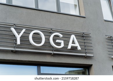 A Building With A Sign For Yoga Classes, Yoga Text Hanging On The Wall, A Sign Of A Club Of Oriental Practices, Advertising On The Street, White Letters In The Name Of Yoga. High Quality Photo