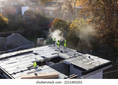 Building Site In Garden, Surrounded By Small Houses And Trees At Autumn. Building The First Floor, Dust From Cutting Stone Spreading In The Air. 