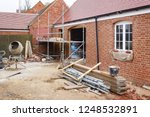Building site in UK with brick house extension under construction
