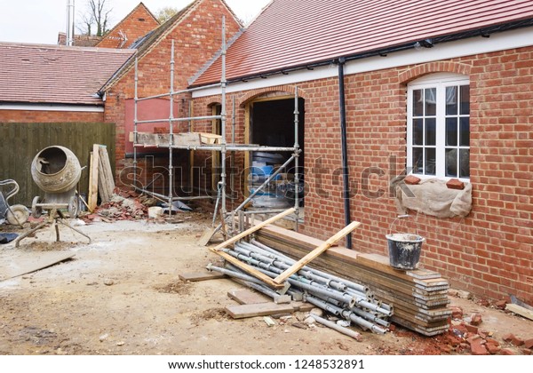 Building site in UK with brick house\
extension under\
construction