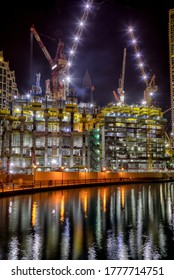 Building skyscraper at construction process during night.