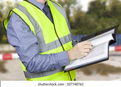 Building Surveyor In Hi Vis Checking Data In Site Folder