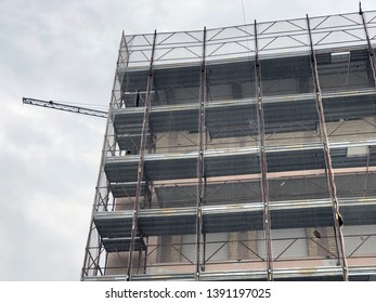 Building Under Construction And A Crane Across The Sky